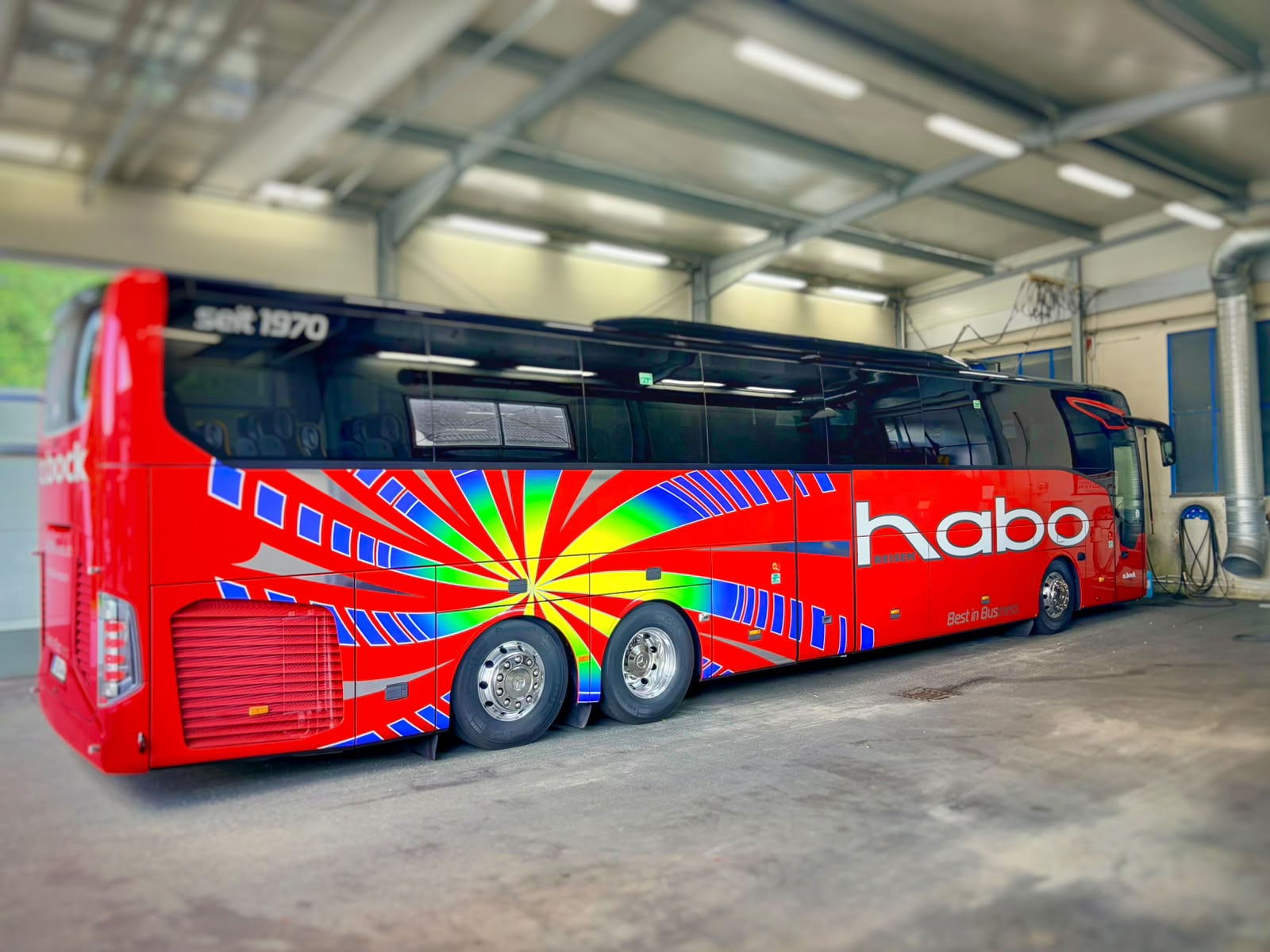 Mehrfarbig folierter Reisebus in einer Werkstatthalle